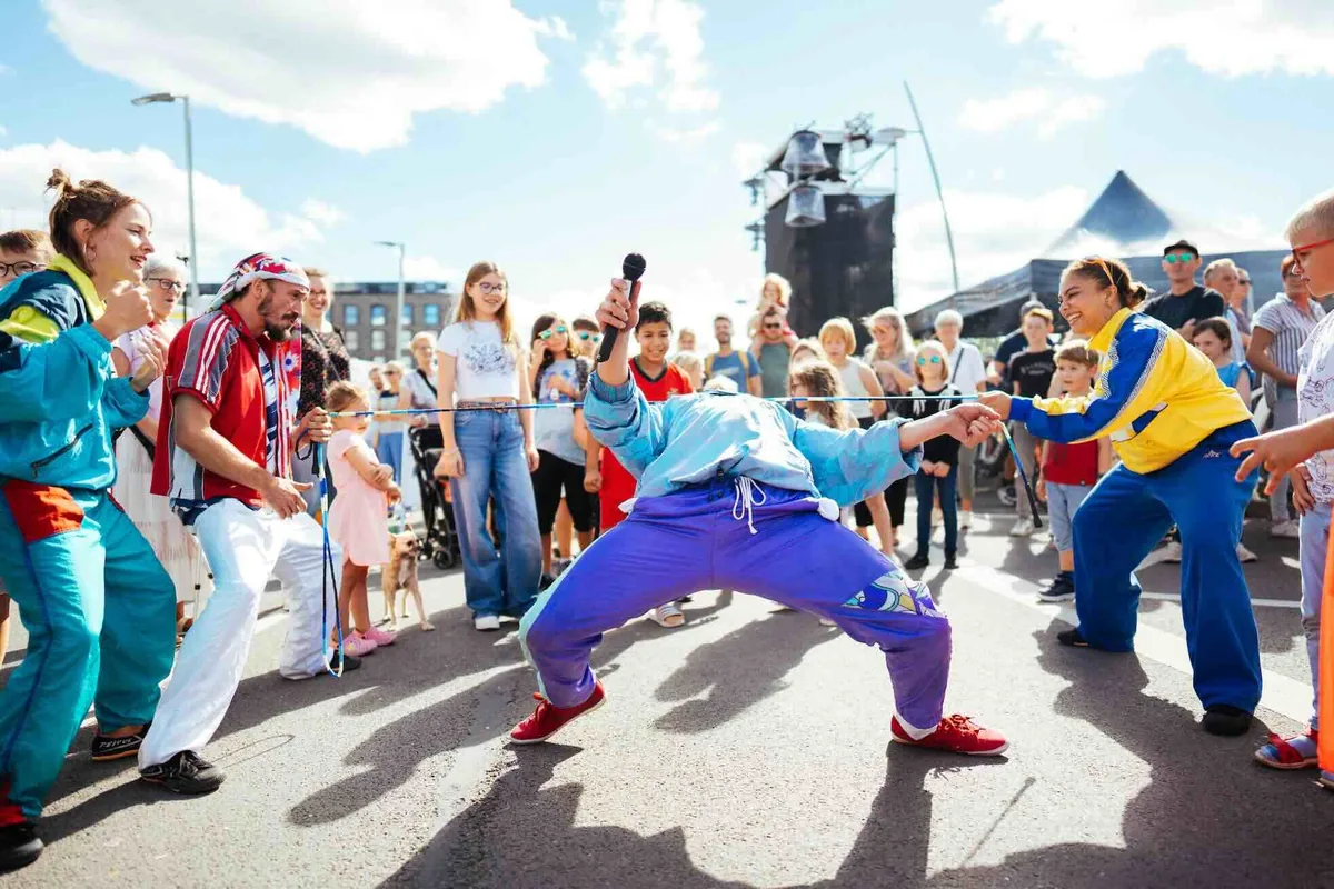 The Funky Monkeys im Funky Walking Act in bunten Kostümen zwischen Festivalgästen.